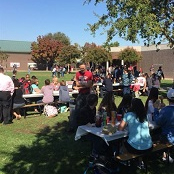 large group of students outside on picnic benches
